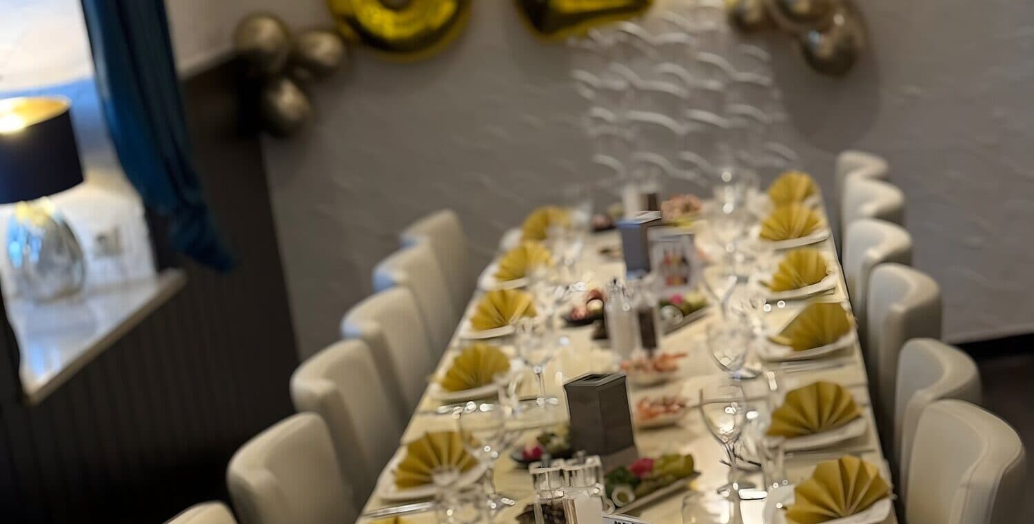 Festlich mit goldenen Servietten und Ballons gedeckte Tafel für eine Geburtstagsfeier in der Taverne Mykonos