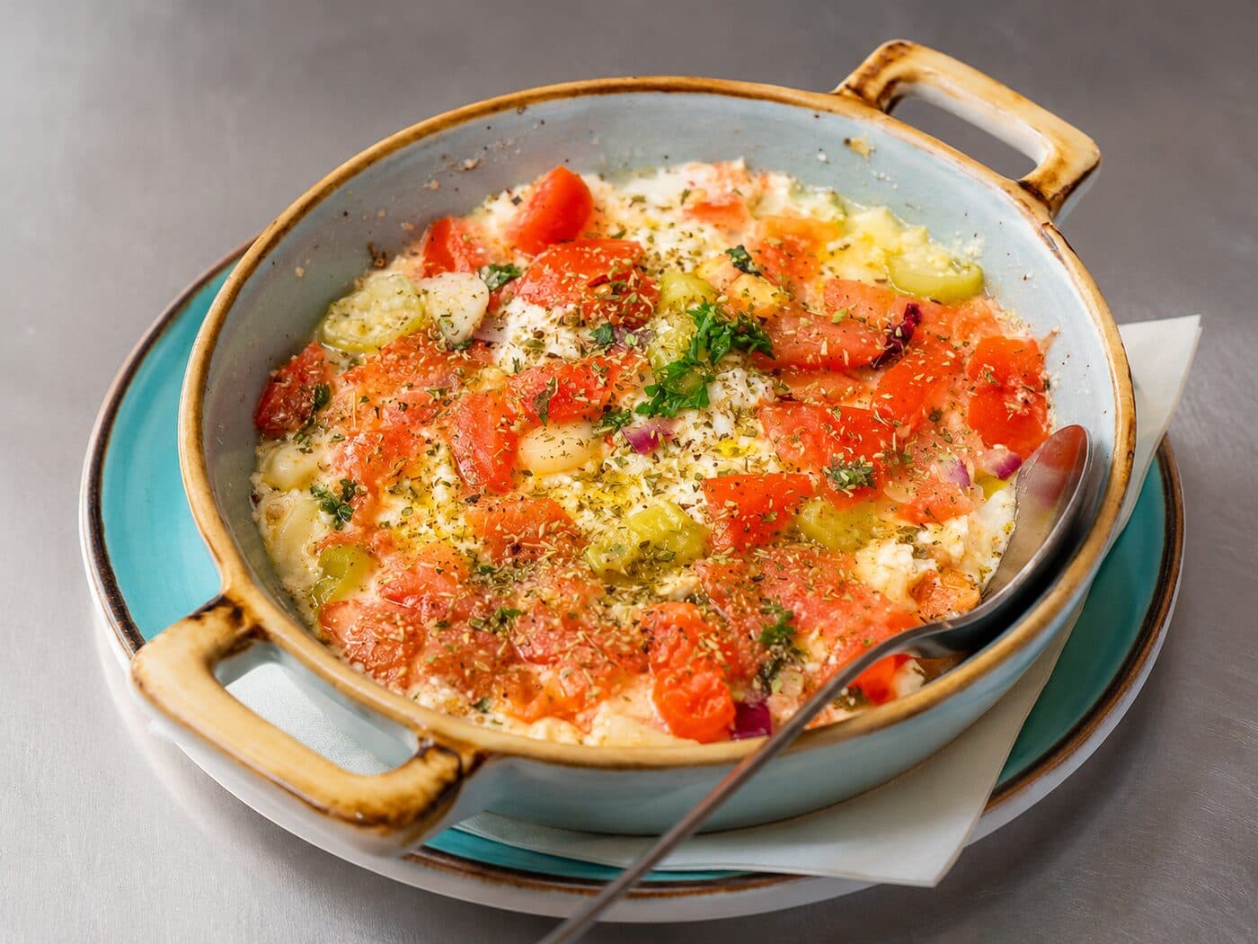 Überbackener Feta mit Tomaten, Peperoni und Kräutern in der Pfanne der Taverne Mykonos