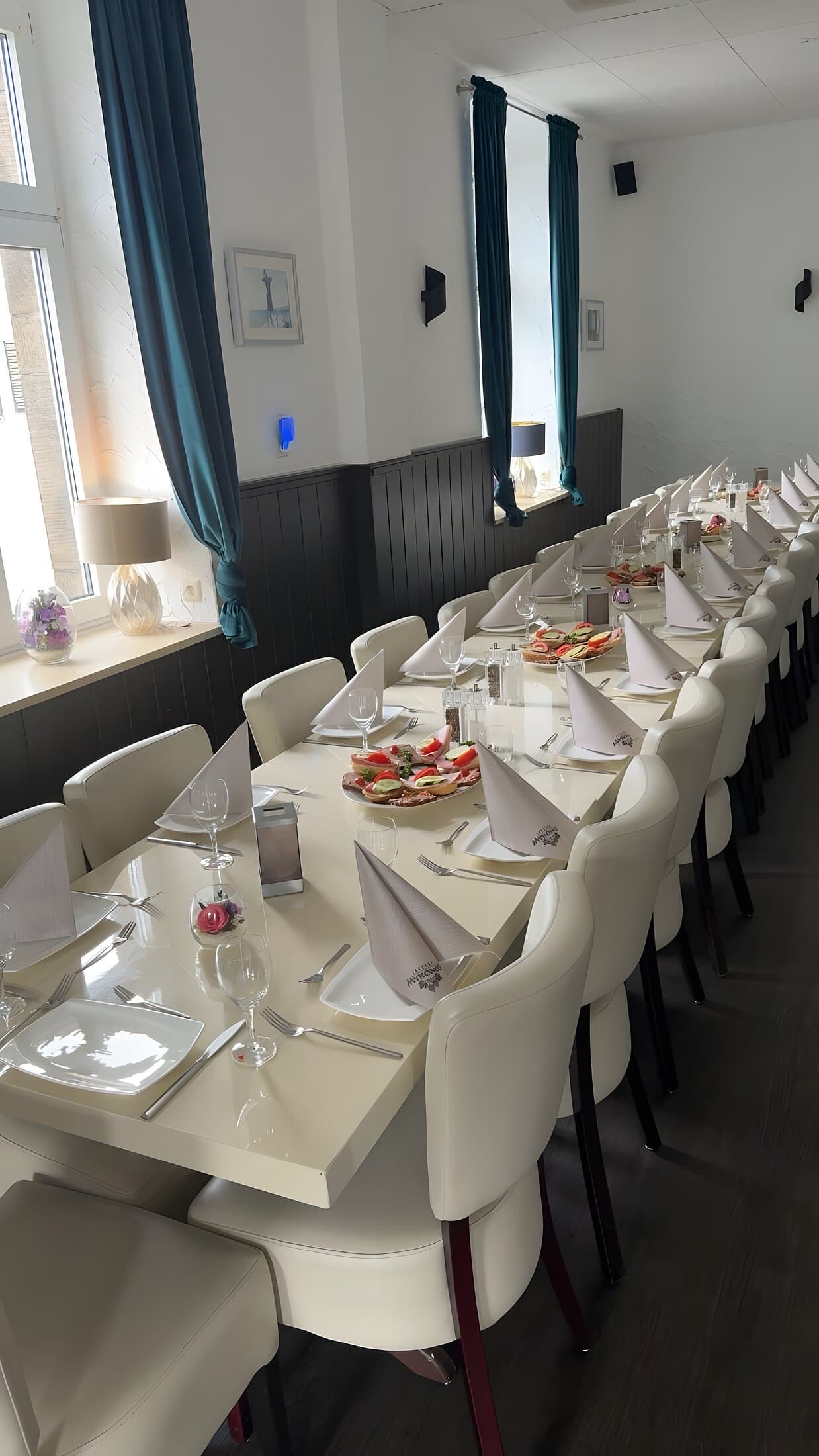 Würdevoll und schlicht gedeckte lange Tafel für eine Trauerfeier